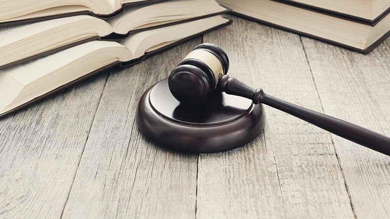 Gavel and books on wooden surface