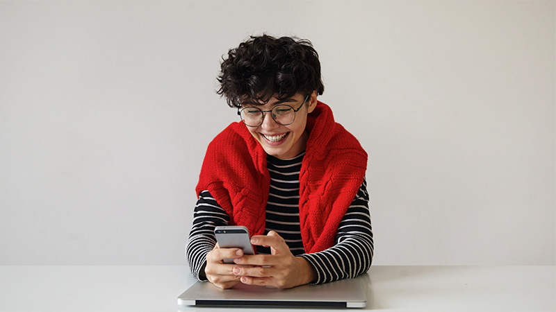 Woman sitting at a table and looking at her phone