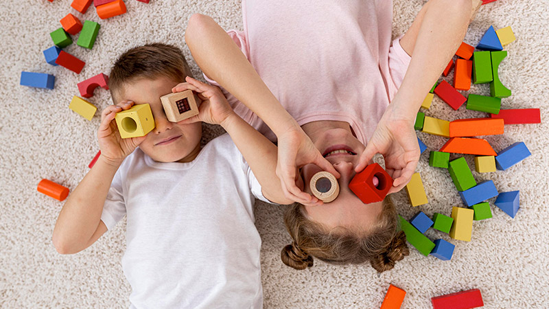 Spin-Master-delivers-the-joy-of-play Kids lying on floor palying with wooden blocks