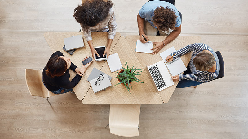 Group of people sitting at table with one empty seat