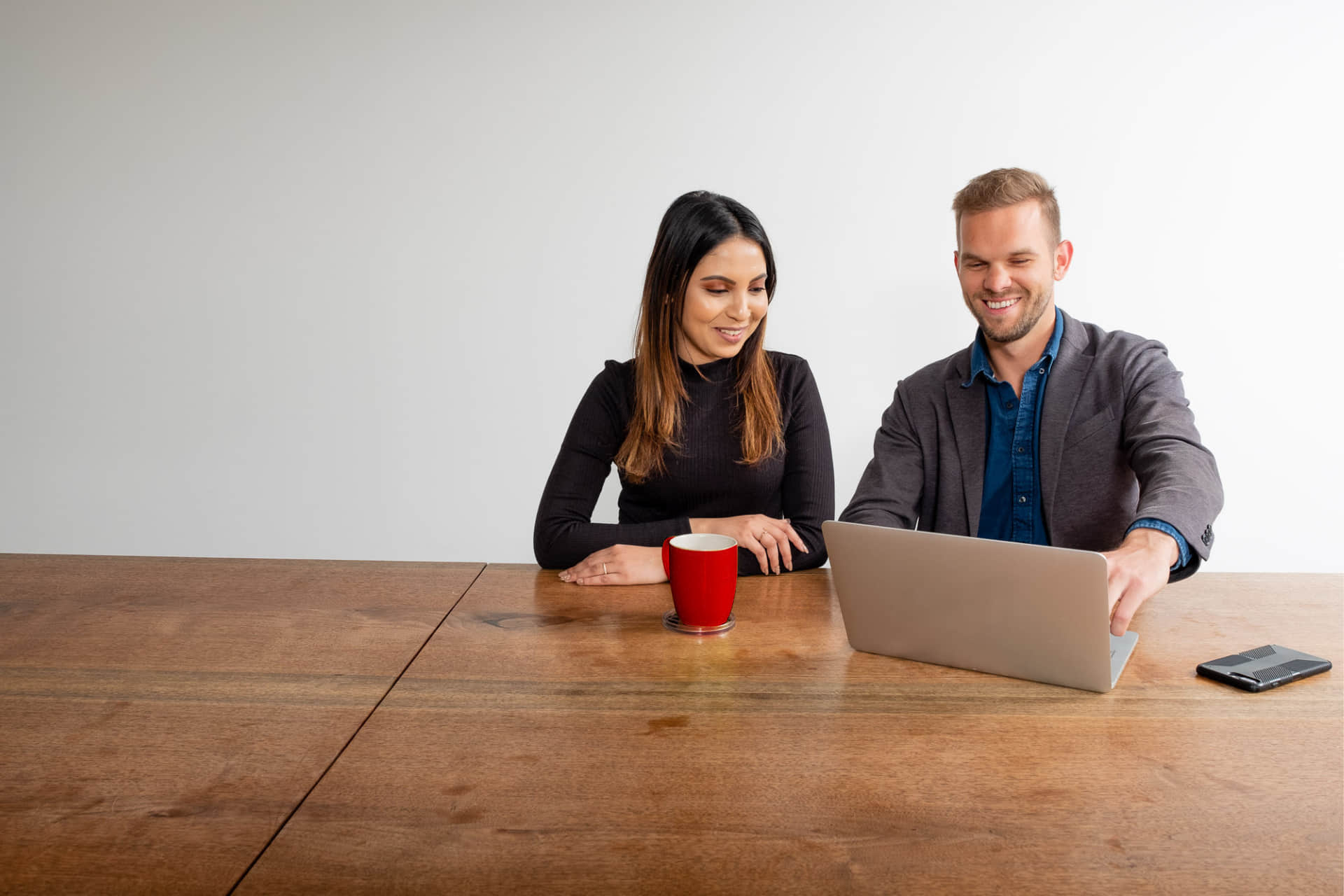 Smiling professionals at desk.